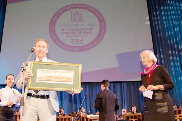 Президент РБА В. Р. Фирсов вручает Медаль Российской библиотечной ассоциации и подарок директору Государственной универсальной научной библиотеки Красноярского края Т. Л. Савельевой