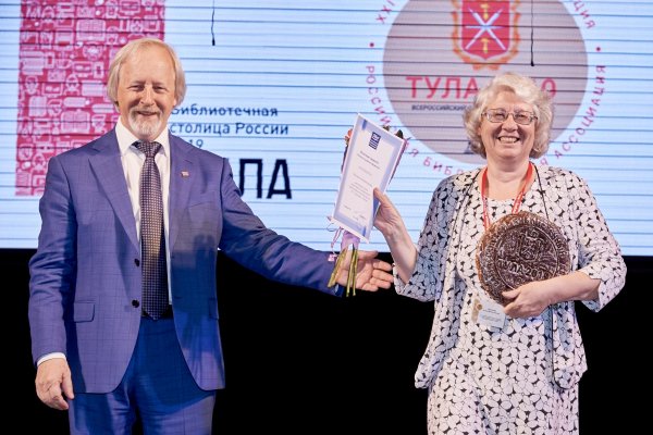 Президент РБА М. Д. Афанасьев награждает Почётной грамотой РБА заведующую отделом редкой книги и мемориальной работы Библиотеки-читальни им. И. С. Тургенева Е. В. Николаеву